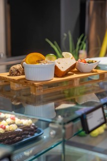 Different types of bread and spreads on a wooden tray in a modern glass display case, breakfast at