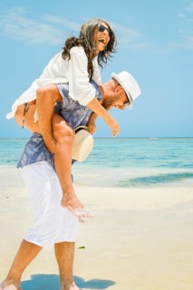 Beautiful traveler tourist happy couple walks piggyback in tropical beach in Maldives island.