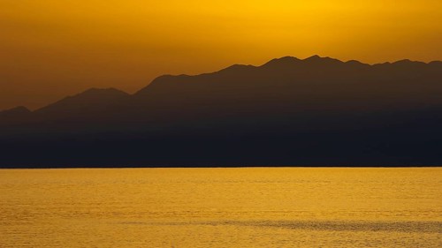 View of sea and mountains at sunset with golden sky, Matala, South Coast, Crete, Greek Islands,