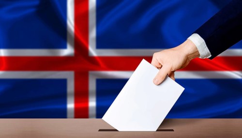 Iceland Election vote. Hand placing a ballot in ballot box with the Icelandic flag in the