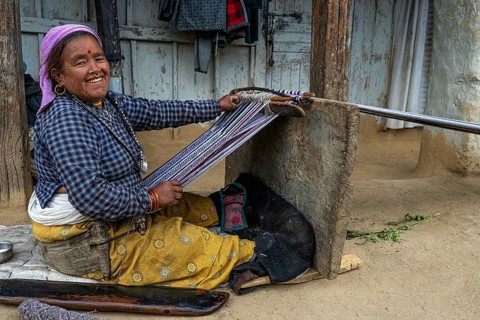 Portrait of a friendly smiling elderly woman sitting at a loom, Hindu ethnic group, Himalayas,