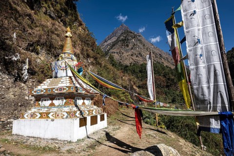 Sacred Buddhist stupa, including choirs with prayer flags on the way to the Tsum Valley, Himalayas,