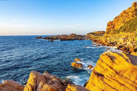 Landscape of the coastline with blue water at Costa Paradiso on a sunny day at sunset, Sardinia,