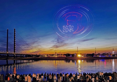 Rhine fair with Rheinkniebrücke, many people watch the drone show with Fortuna logo, Düsseldorf,