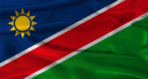 Flag of Namibia with fabric textured background. Close up of National flag of Namibia with