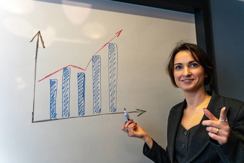 Smiling Businesswoman Explaining Growth Chart on Whiteboard