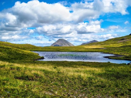 Idyllic mountain lake Lochan am Bealach a' Mhàim, distinctive high pass, cone-shaped mountain
