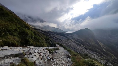 A rocky hiking trail snakes through the cloudy mountain landscape, hiking in the High Tatras