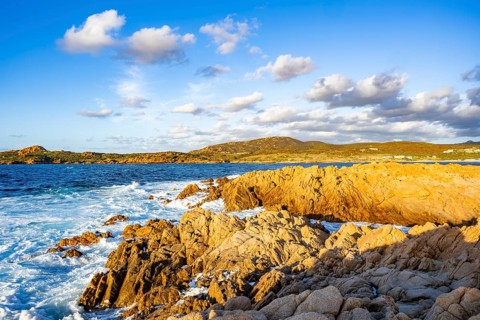 Landscape of the coastline with blue water at Marinedda Coast at sunset, Sardinia, Italy