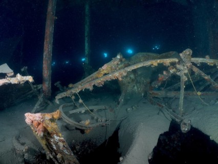 Weathered remains of a wreck under water, overgrown by algae, mysterious darkness. Wreck of the Vis
