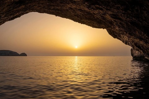 Seen from the Blue Grotto off Cabrera (Majorca), the sun sets on the horizon over the sea, Cabrera,