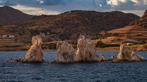 Rocks and blue lake against a mountainous landscape under cloudy sky, Aspragremna, White Cliffs,
