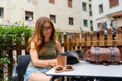 Young millennial woman wearing glasses and casual clothes working remotely on a digital tablet at