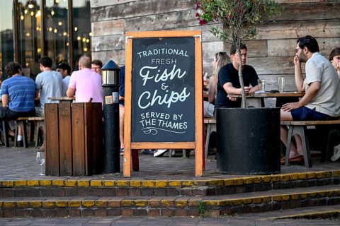 Fish & chip sign in front of an outdoor restaurant on the Thames, South Bank, London, England,