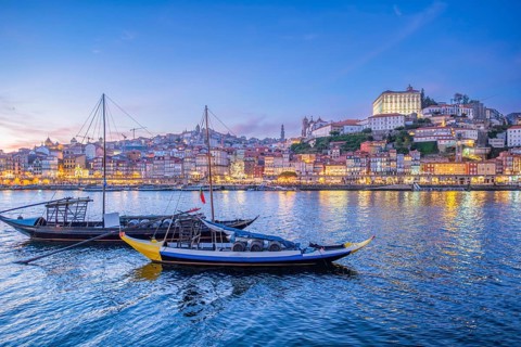 Night view of Porto rabelo boats on Douro River by Ribeira, Portugal, with evening twilight, blue