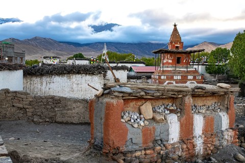 Buddhist stupa, also chords, painted in the foreground on clay wall with Buddhist colors red,