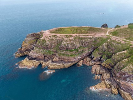 Aerial view of the rocky cliffs at Cap Fréhel with the historic Vauban lighthouse, 17th century
