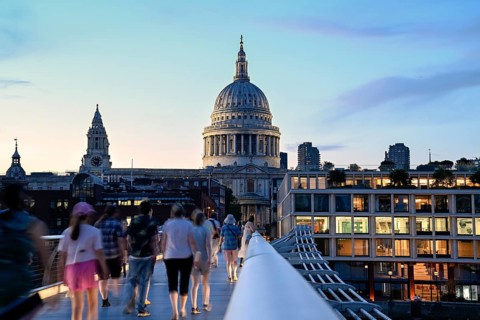 Evening scene on the Millennium Bridge over the Thames, blue hour, in the background St Paul's