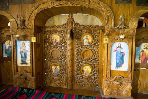 Detail of the intricately carved iconostasis of an Orthodox altar with images of saints, cave