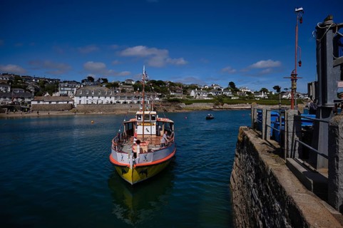 Ferry sails in harbour, in the background luxury hotel THE IDLE ROCKS, St Mawes, Cornwall, England,