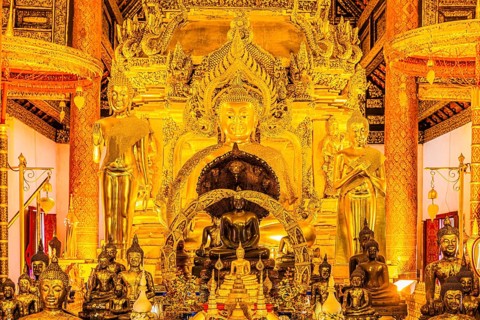 Sumptuous interior with richly decorated wooden ornaments, gilded Buddha statues, Buddhist temple
