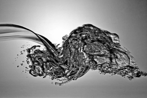 A small longitudinal wave frozen by short exposure in crystal-clear water in the photo studio