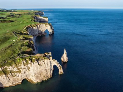 Aerial view of the Porte d'Aval rock formation with the free-standing Aiguille d'Étretat rock pin