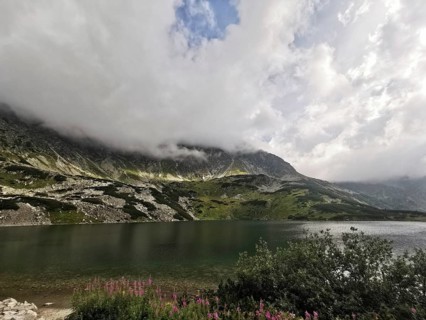 A quiet mountain lake surrounded by cloudy mountains and an impressive sky, Schronisko, High Tatras