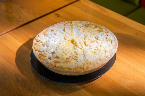 Cake with powdered sugar on a wooden table, ready to serve, Café Kuh, Deckenpfronn, Germany