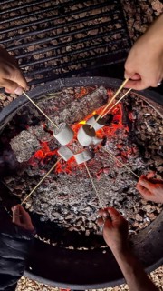 Group of friends gathering around a blazing campfire, enjoying the warmth and joy of roasting sweet