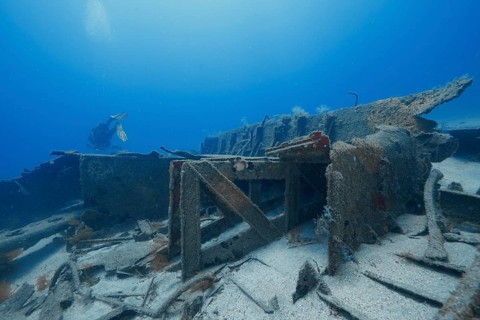 A diver explores the broken parts of an old shipwreck underwater, meteor wreck dive site, Russian