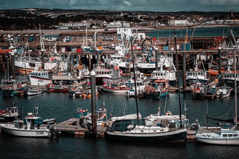 Maritime flair in England:, Numerous fishing boats and yachts close together in the harbour basin,