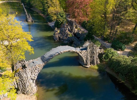Stone bridge with view of autumnal trees and calm water, aerial view, Rakotz bridge, Rakotzsee,