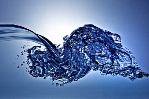 A small longitudinal wave frozen by short exposure in crystal-clear water in the photo studio in