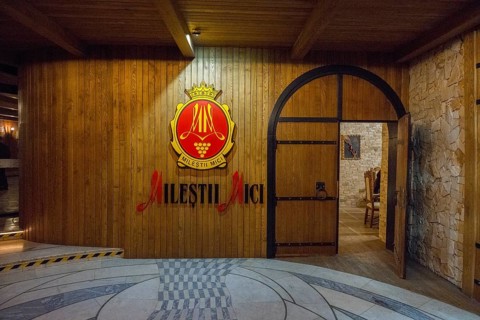Entrance area with 'Milestii Mici” logo on a wood-clad wall, wine cellar, Milestii Mici Winery,