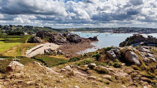 Rocky coastal landscape with beach and blue sea under a cloudy sky, The coastal landscape near