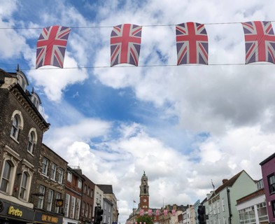 Union Jack bunting flags in a line strung across High Street in town centre of Colchester, Essex,