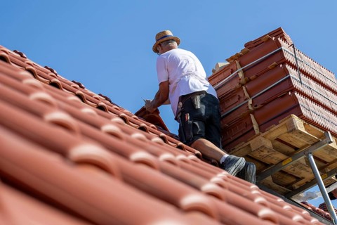 Carpenter or roofer covering a tiled roof in the Palatinate. The temperatures rise to over 35