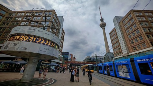 People on Alexanderplatz with a view of the World Clock, the Berlin TV Tower and a tram,