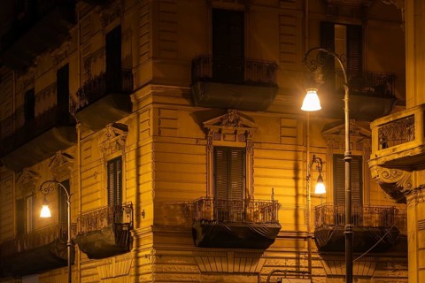 Facade of a neoclassical building at night, accentuated by the light of street lamps, Palermo,