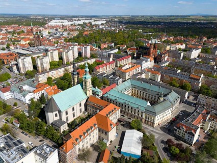 Aerial view of a city with historic buildings, several churches and parks, in a sunny atmosphere,