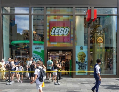 People in line queuing outside flagship Lego store shop, Swiss Court, Leicester Square, London,