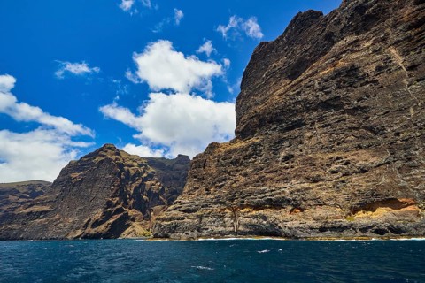 Los Gigantes, high rocks with distinctive cliffs under a cloudy sky over the sea, whale watching