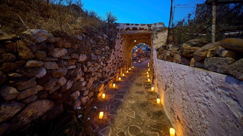 Open-air cinema, a well-lit stone path at night flanked by stone walls and lanterns, Kastro, old