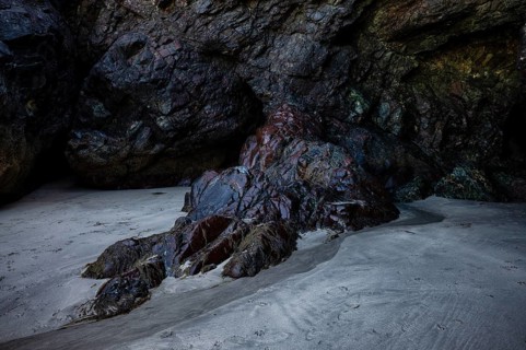 Wet rock in cave glows in various colors, coast, rock formations, rocks, sandy beach, beach,