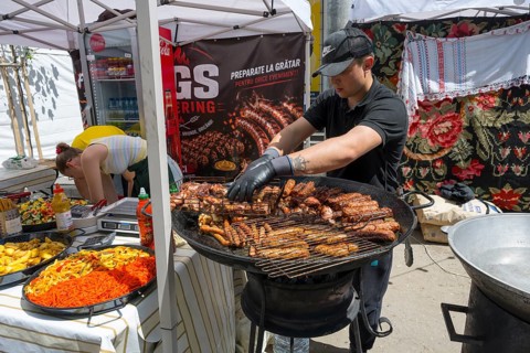 A man grilles pieces of meat on a stand at a street party, folklore festival, Chisinau, Chisinau,