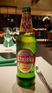An Ožujsko beer bottle is on a table in a finely decorated restaurant, Croatia