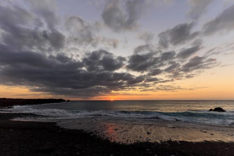 Lanzarote, Canary Islands, Spain, Europe, Los Hervideros, An almost hidden sunset with clouds and a