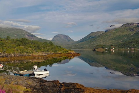 Lake with mountain views, small boat dock and cloudy sky create a peaceful landscape, calendar