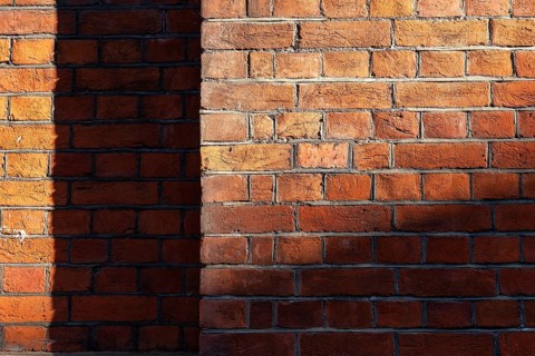 Brick wall made of brown-red, partly shaded bricks, Chelsea, London, England, Great Britain